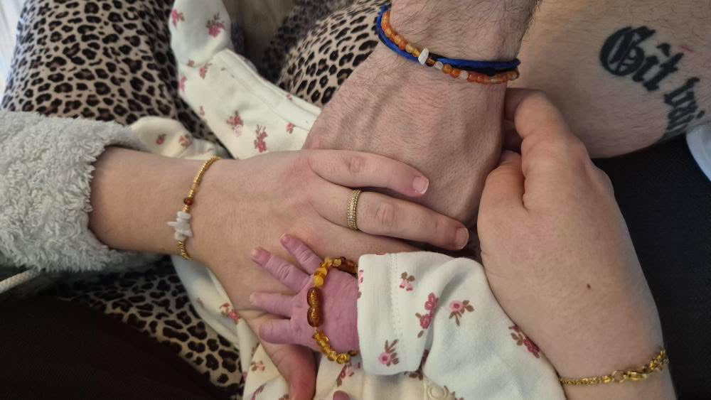 Photo de parents et d’un bébé portant les bracelets famille assortis.