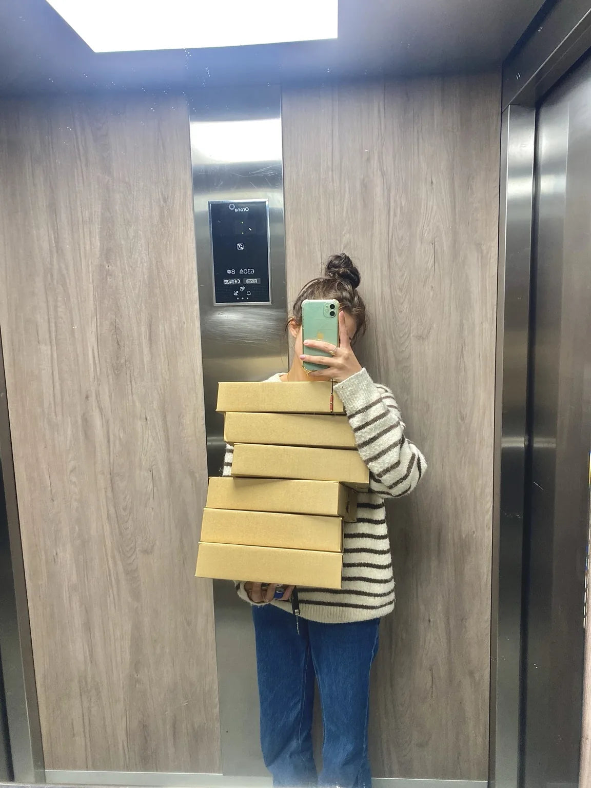 Camille portant plusieurs colis KEUR prêts à partir.